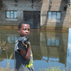 A young boy walks past a flooded home in Inchope, Mozambique, March 25, 2019.